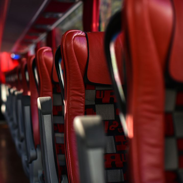 An empty charter bus cabin lined with plush seats